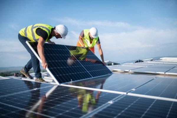 Team of two engineers installing solar panels on roof. Team of two engineers installing solar panels on roof.